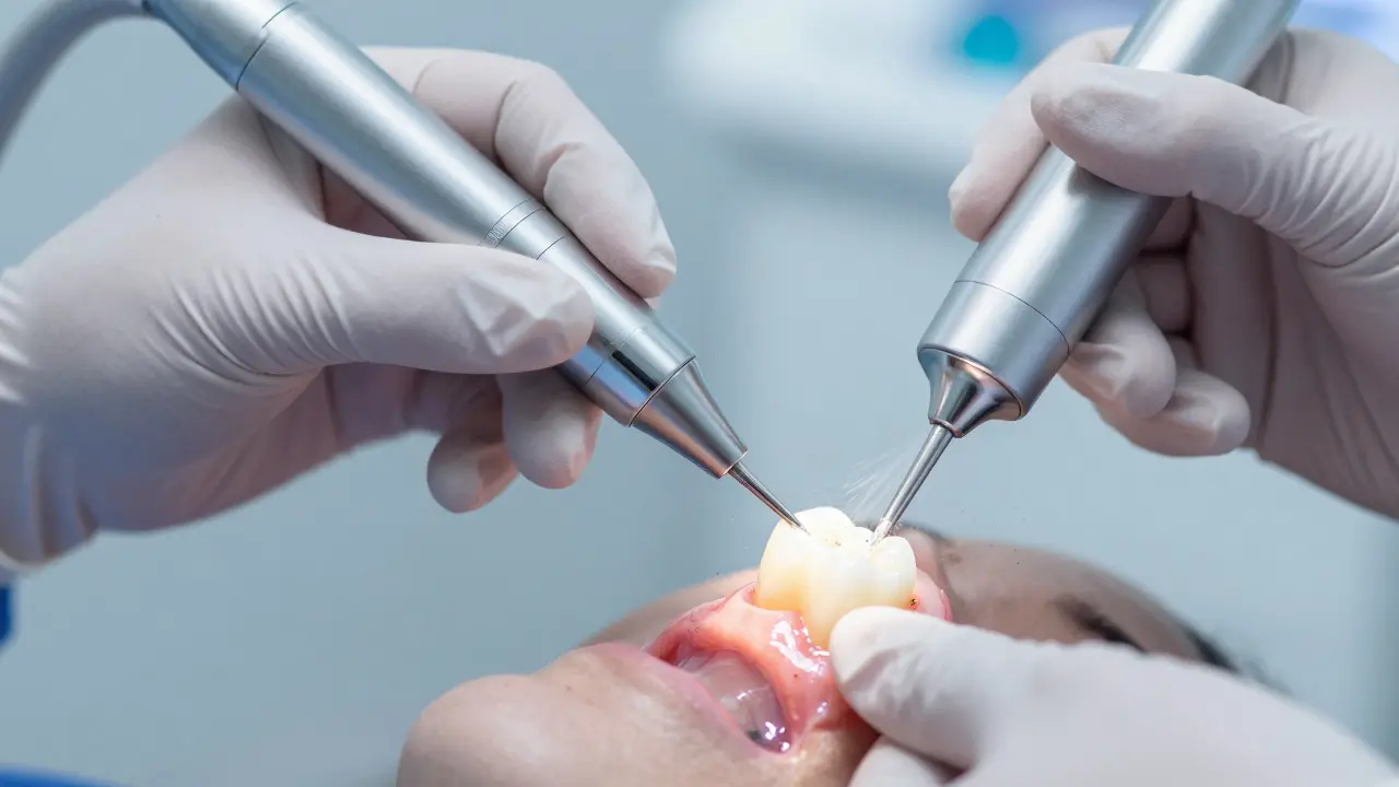 Dentální hygienistka čistí zuby ultrazvukovým skalpem